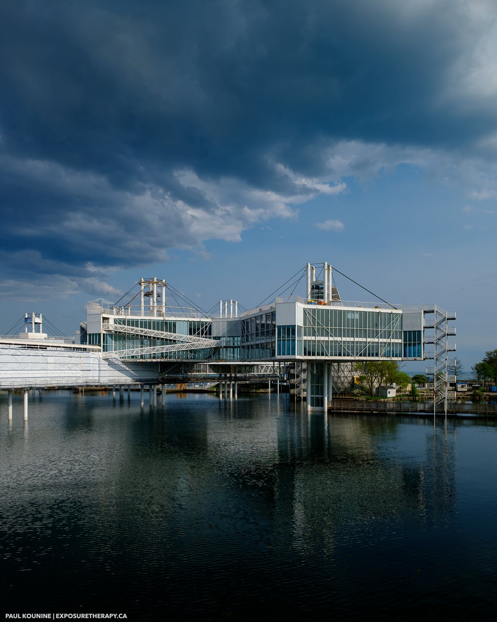 Clouds over ontario place event centre with water reflections and construction.